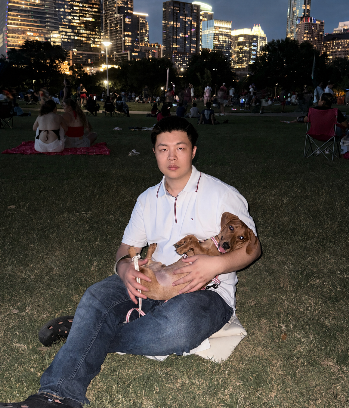 Junhao Wu with a dog in front of the Austin skyline